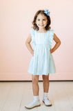 A little girl wearing the Blue Striped Dress with ruffle details will shine this spring at any special occasion.