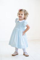 The Classic Blue Smocked Dress is available in sizes 12M to 8, ensuring a perfect fit for growing girls.
