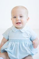 The Classic Blue Smocked Arthur Bubble for baby boys and toddlers features hand-smocked details, offering a timeless, heirloom-quality design.