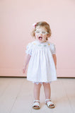 Dressed in the smocked sprinkles birthday cake bloomer set, a little girl radiates joy and sweetness during her celebration.