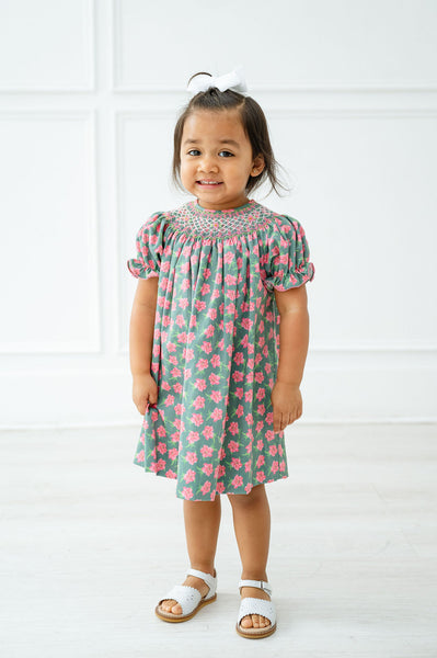 A little girl wearing the smocked azaleas Helen dress radiates elegance at any spring celebration.