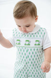 A little boy wearing the Smocked Green Golf JonJon looks adorable with its playful green golf cart design on the smocked bodice.