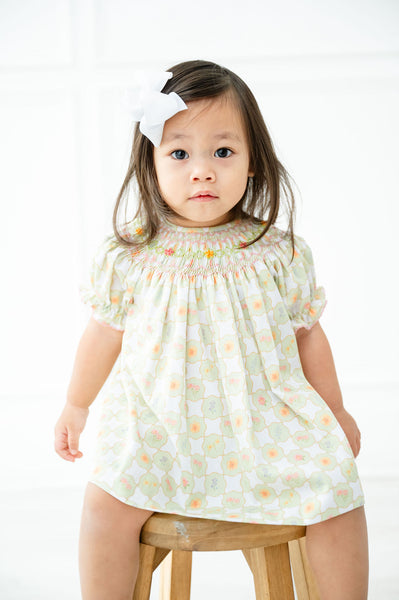 A little girl wearing the Smocked Wildflower Bloomer Set will be ready for any spring occasion with its charming light green and white checkered pattern.