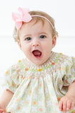 
A little toddler girl wearing the Smocked Wildflower Bubble will be ready to bloom this spring with its charming light green and white checkered pattern.