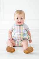 A baby boy wearing the Colorful Plaid Alexander Bubble is ready for any springtime outing, looking cute and stylish.