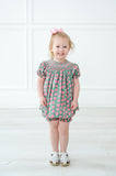 A little girl wearing the pink and green smocked bloomer set looks radiant at any spring celebration.