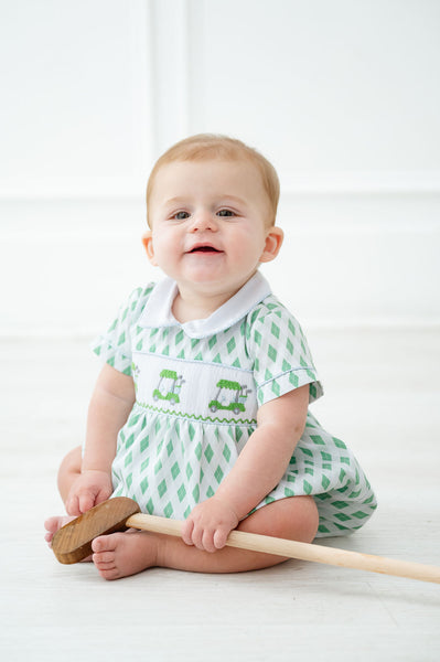 A little boy wearing the Smocked Green Golf Bubble looks absolutely adorable with its playful green golf carts on the smocked bodice.