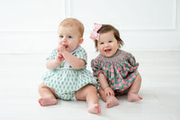 A little girl wearing the pink and green azalea smocked birdie bubble is the picture of elegance at any spring occasion.