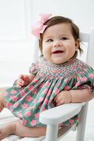 The pink and green azalea smocked birdie bubble features a delicate smocked bodice with deep pink azaleas.