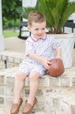Young boy modeling a soft Pima cotton football-print romper with polo collar, perfect for tailgates and game days