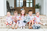 Siblings wearing matching Pima Football game day prints, featuring footballs and tailgate motif with red piping