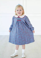 girl wearing beautiful blue floral dress with smocking on chest