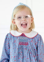 girl wearing blue floral dress with smocking on chest