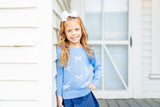 Girl wearing blue and white bows sweater.