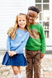 Girl standing with boy wearing blue bows sweater.