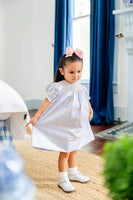 girl wearing blue, orange and yellow smocked dress