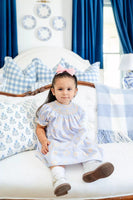 girl wearing blue, orange and yellow smocked bloomer set