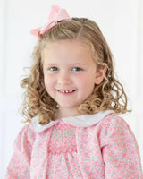 close up of Girl wearing smocked pink floral dress