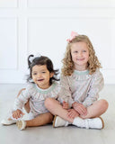 girls wearing pink and green floral ruffle dress and bubble