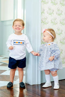 boy and girl wearing smocked pumpkin outfits