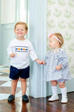 boy and girl wearing smocked pumpkin outfits