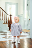 girl wearing smocked floral and pumpkins bloomer set