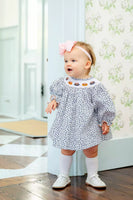 girl wearing smocked floral and pumpkins bloomer set