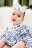 girl wearing smocked floral and pumpkins bubble