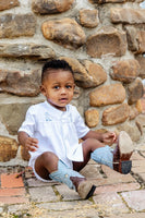 Toddler boy wearing hand embroidered blue cowboy boots layette set and boots.