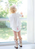 Toddler girl wearing pink hand embroidered cowgirl boots layette set.