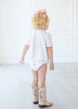 Toddler girl wearing pink hand embroidered cowgirl boots layette set.